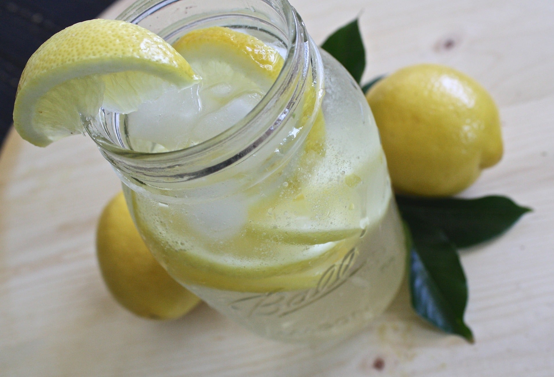 Einmachglas mit Wasser, Eis und Zitronenspalten