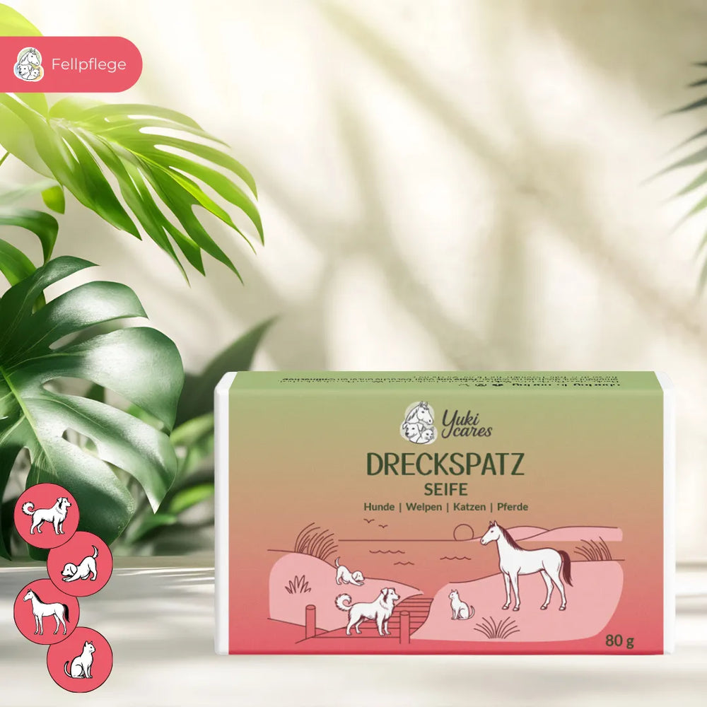 Eine Seifenverpackung für die Fellpflege von Tieren mit Illustrationen von Hund, Katze und Pferd steht vor grünen Blättern.