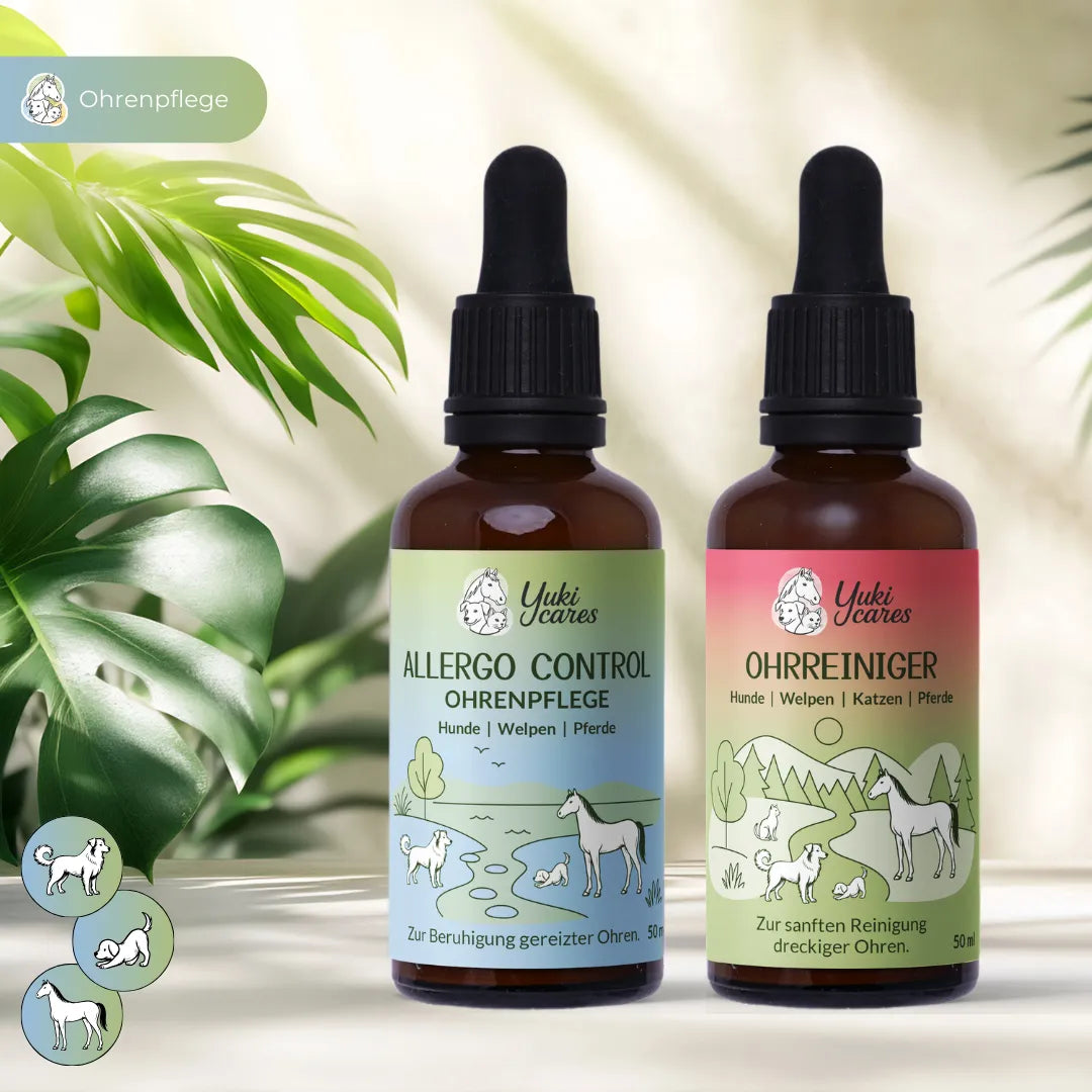 Zwei Yuki Cares Ohrpflegeflaschen für Tiere stehen neben grünen Blättern auf einem Tisch.