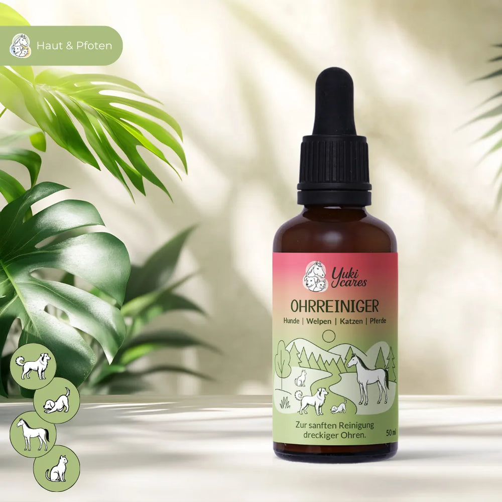 Eine Flasche Yuki Cares Ohrenreiniger steht auf einem Tisch, umgeben von grünen Blättern für Haustiere.